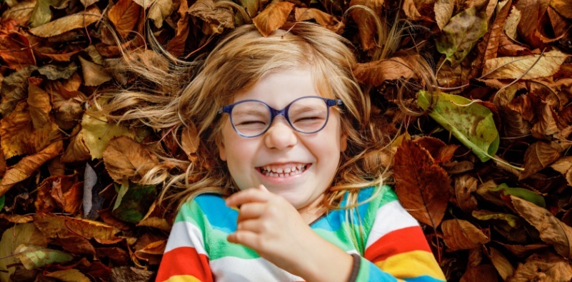 kid playing on leafy ground